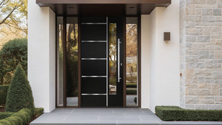 A modern black front door with horizontal silver accents and glass sidelights is set into a contemporary house entrance with stone and white brick.