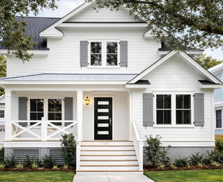 White farmhouse exterior with gray shutters and black front door