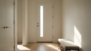 Modern white entryway with front door, bench, and natural light