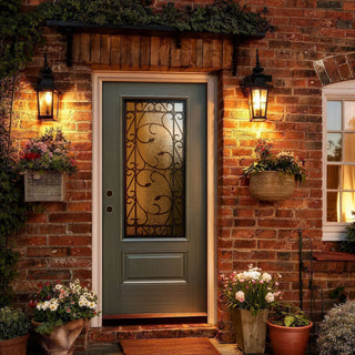 Textured green fiberglass entry door with wrought iron 3/4 lite glass, set in brick exterior with lanterns and flowers.